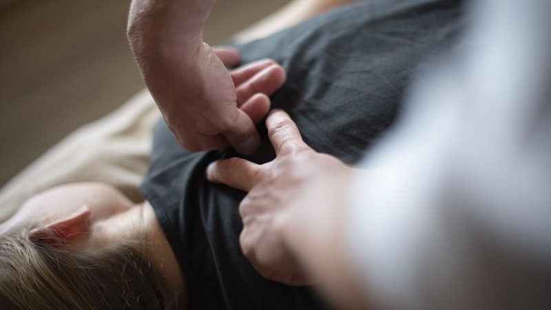 Hands performing spinal decompression therapy on a patient's back